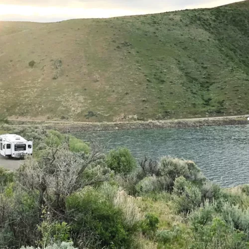 White RV boondocking beside a lake